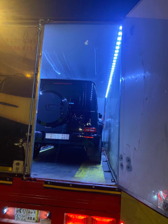 نقل سيارة مرسيدس G-Class بسطحة مغلقة مع إضاءة زرقاء